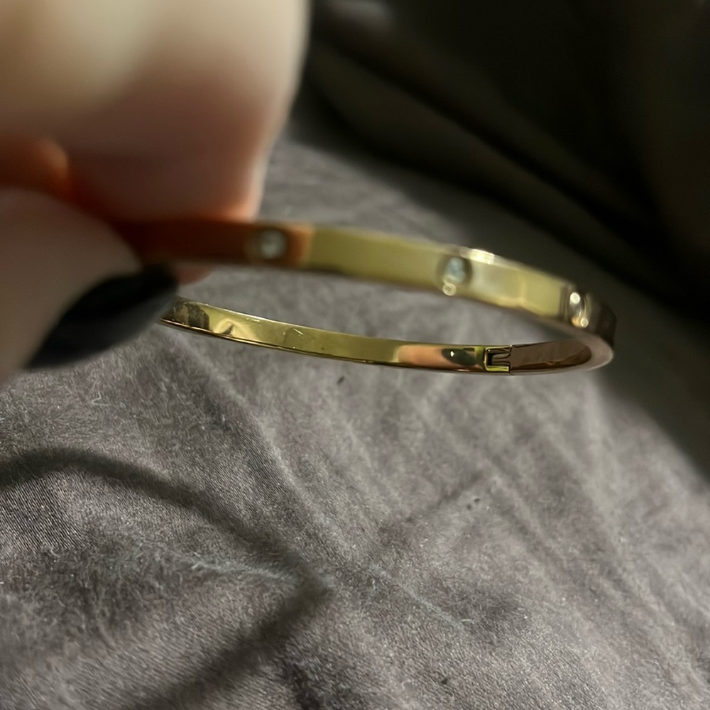Rose- colored stainless steel bangle with 10 rhinestones around.